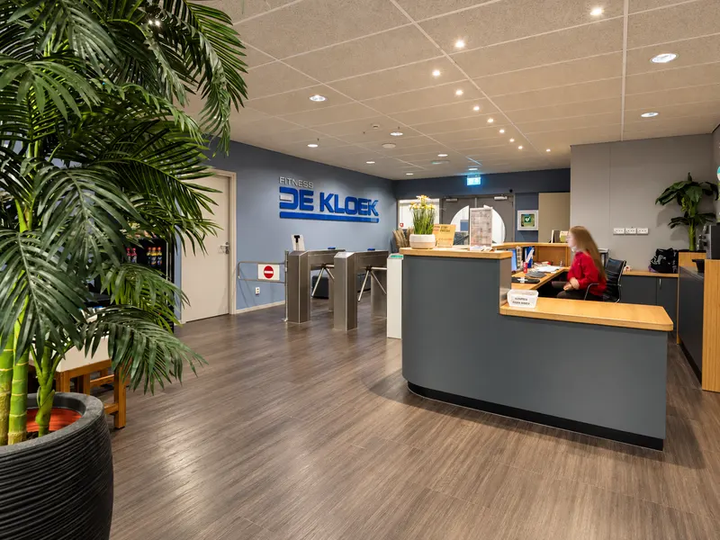 Receptie van De Kloek Fitness met het logo op de wand